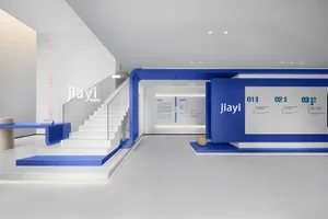 A modern corporate office with a white and blue color scheme featuring a staircase and a display wall.