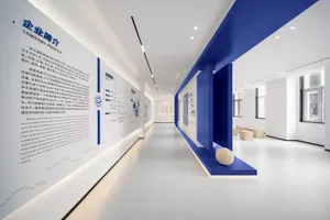 Modern office corridor with white concrete walls and blue accents showcasing company profile information.