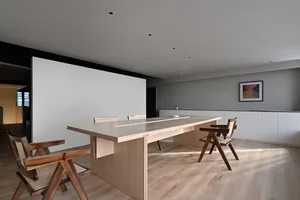 A modern residential dining room with a wooden table and chairs.