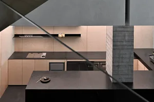 A modern kitchen with industrial design elements featuring concrete countertops and wooden cabinets.