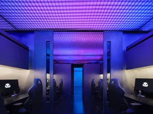 An industrial gaming lounge with metallic decor and purple lighting.