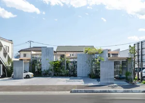 A modern house with a concrete exterior and large glass windows.
