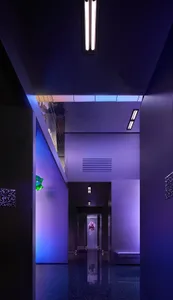 A modern, minimalist hallway with illuminated lighting fixtures.