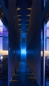 A sleek, modern hallway with glass walls and metallic accents.