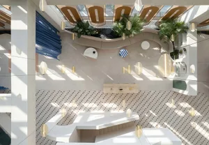 A modern office space featuring white marble surfaces and an open, airy design with natural light streaming in.