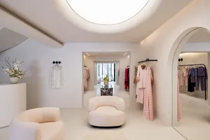 Modern retail store with plush seating and elegant clothing displays.