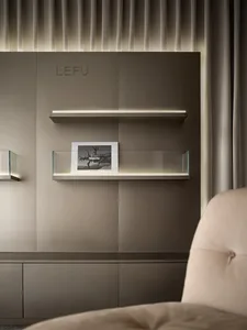 A modern shelf display featuring a glass shelf holding a framed photo, with additional glass shelves and cabinets in the back