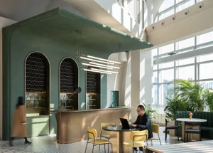 A modern cafe with concrete walls, brass accents, and large windows allowing natural light to fill the space.