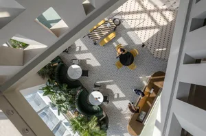 A modern office lobby with concrete flooring and seating areas.
