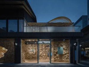 Stone and glass storefront of an Arc'teryx store at dusk