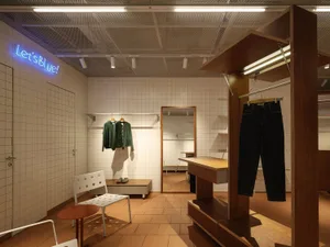 Modern clothing shop interior with wooden elements and a minimalist aesthetic.