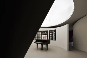 Modern minimalist black and white interior with a piano and color charts.