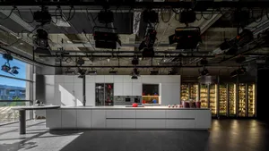 Modern kitchen featuring white concrete countertops, minimalist design, and industrial lighting.