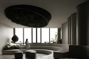 A modern living room with concrete and glass features.