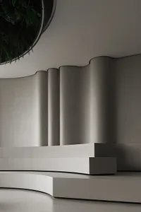 A modern lobby interior with a curved, concrete bench and wall.