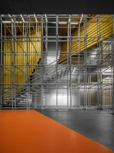 A modern office space featuring metal scaffolding frameworks.
