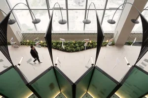 A modern office space featuring a sleek staircase made of glass and metal.