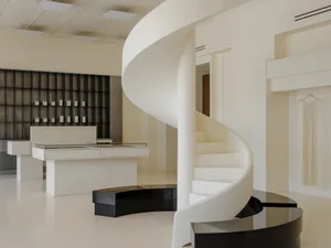 A modern retail shop featuring a white concrete staircase and black floating bench.