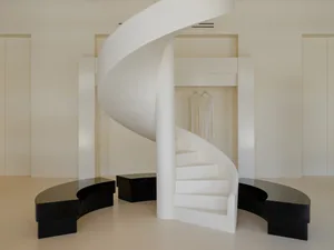 White minimalist retail space with a spiral staircase.