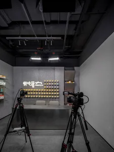 An industrial-style retail space featuring a concrete wall with a neon sign and yellow products displayed on shelves.
