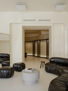 A modern retail store with concrete flooring and leather seating.