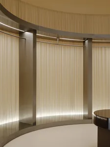 A minimalist interior design featuring curtains made of a soft, flowing textile material.
