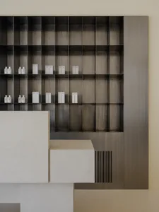 A minimalist retail space featuring metal shelves and concrete elements.