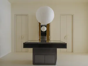 A minimalist interior with a metallic black table and white lamp.
