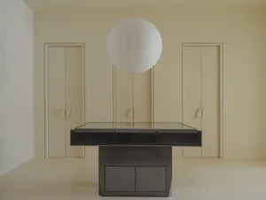 A minimalist black-and-white interior with a metal and glass table, white floor, and ceiling light.