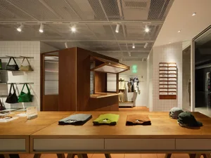 Modern retail space featuring a clothing store with wooden fixtures and tile walls.