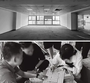 A black and white photograph showcasing the interior of a renovated office space with a concrete floor.