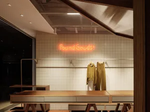 Clothing display in a modern retail store interior with a tiled wall.