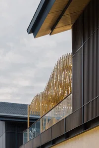 Modern building exterior featuring sleek metal, wooden, and glass architectural elements.