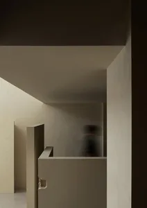 A minimalist interior space with concrete and plaster elements.