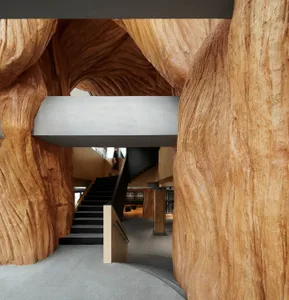 Modern architectural space featuring wooden columns and a staircase.