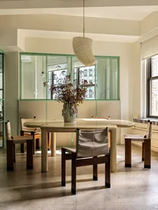 Modern dining room with an integrated glass window and wooden furniture.