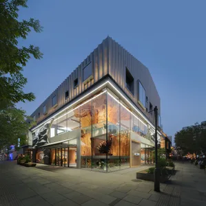 A modern industrial storefront with glass walls and metal accents.