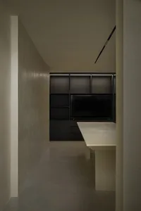 A modern kitchen with a concrete countertop and minimalist design.