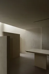 A modern minimalist office space featuring concrete and wooden elements.
