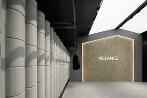 A modern retail storefront featuring concrete columns against a black ceiling and minimalist design.