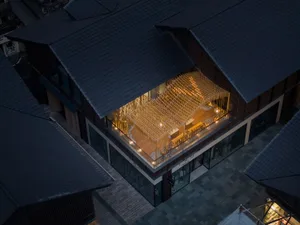 Modern retail interior with lit wooden structures and large glass windows.