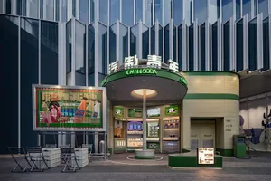 Modern storefront with metallic facade, glass windows, and concrete elements.