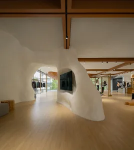Modern retail space featuring curved, concrete walls with a minimalist design.
