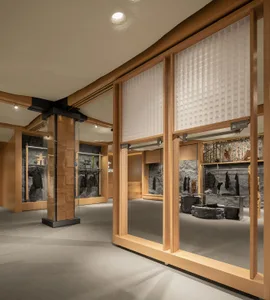 A retail store interior featuring wooden walls, stone elements, and glass displays.