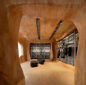 A retail store interior with wooden walls, floors, and an organic, curved design.