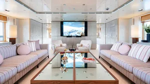 Modern living room with sofas, chairs, coffee table, and large screen TV.