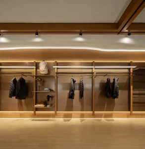 燈光充足的零售空間，展示現代服裝於衣架與層架上。