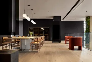 Industrial lounge featuring wooden floors, metal accents, and greenery.