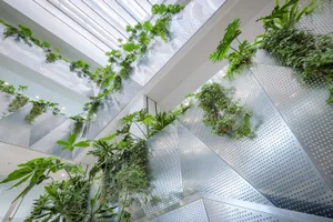 Metal-clad lounge area with various tropical plants and greenery hanging from the ceiling and walls.