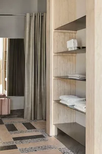A minimalist bathroom with glass shelves, marble accents, and metal hardware, showcasing sophisticated storage solutions.